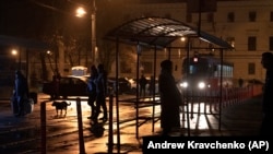 Oamenii așteaptă la o stație de tramvai în timpul unei pene de curent în Kiev, Ucraina, duminică, 6 noiembrie 2022