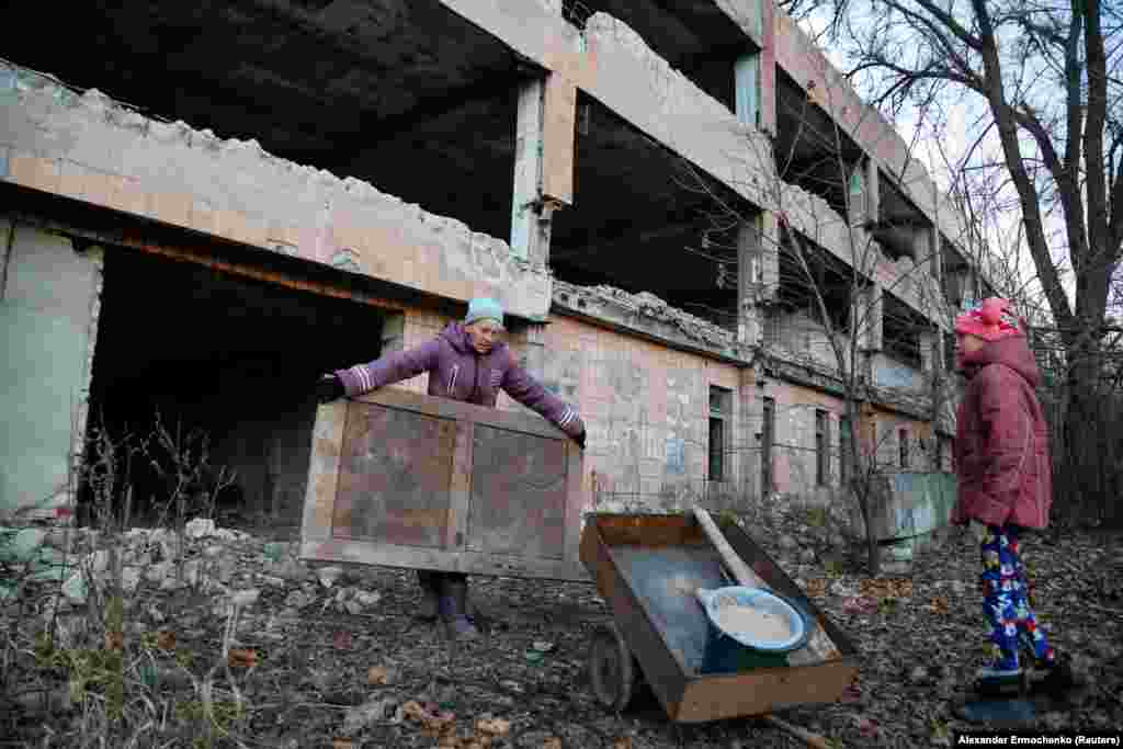 Ангелика (49) и нејзината ќерка Анастасија (13) собираат парчиња мебел за греење во близина на напуштен рудник за јаглен во градот Хорливка, контролиран од бунтовниците, во близина на Доњецк, во Украина. (24 ноември)