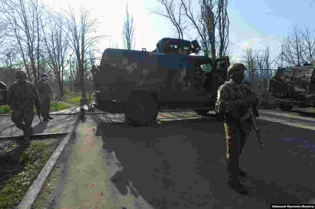 Припадници на украинските вооружени сили, стојат до оклопни возила, на борбени позиции, на линијата на поделба од проруските бунтовници, во Широкине, во регионот Доњецк, во Украина. (21 април)