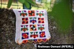 Copë nga koleksioni i rrobave tradicionale të Arbnora Kolgjeraj Rexha dhe Lajde Kolgjera e varur në një gur.