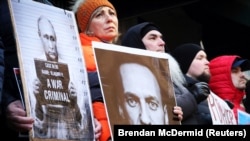 Demonstranti drže slike sa Vladimirom Putinom i Aleksejem Navaljnim na skupu u blizini ruskog konzulata u New Yorku nakon vijesti o smrti Navaljnog 16. februar 2024.