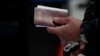 Një qytetar duke mbajtur në dorë një pasaportë të Republikës së Kosovës. Fotografi nga arkivi.