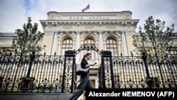 Жена поминува покрај седиштето на Руската централна банка во центарот на Москва.