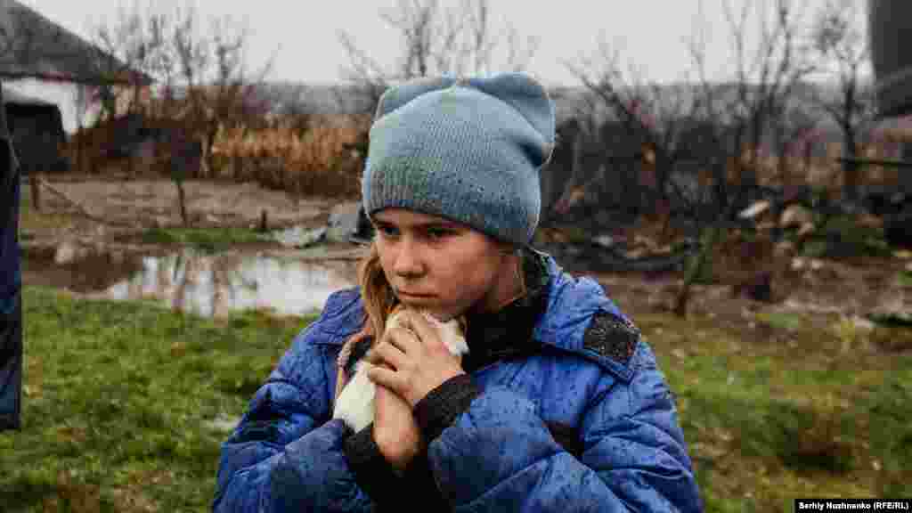 19 noiembrie 2022. Sofica, o fetiță de 9 ani, își protejează porcușorul de Guineea în timpul evacuării de la Makivka, în regiunea Luhansk.