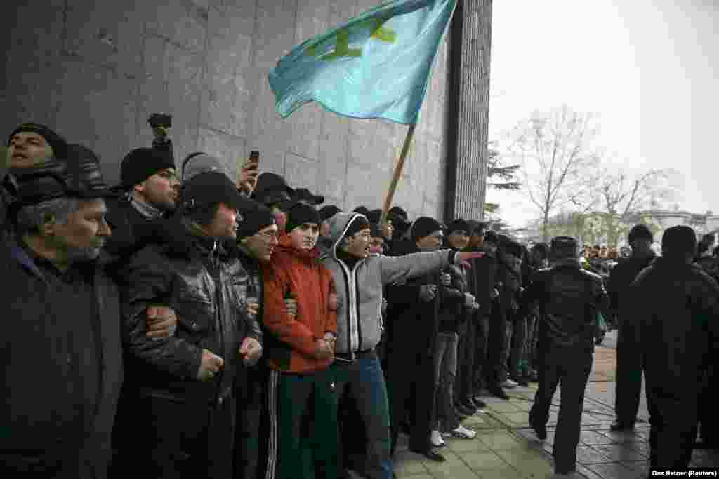 Krimski Tatari drže zastavu svog naroda kod krimskog parlamenta u Simferopolju 26. februara 2014. godine. Nedelju dana ranije, krimski političar je ukazao na mogućnost &quot;otcepljenja&quot; poluostrva od Ukrajine. Demonstranti na ulicama Krima u to vreme su radili na svrgavanja proruskog predsednika Viktora Janukoviča u, kako su Ukrajinci to nazvali, &quot;revoluciji dostojanstva&quot;.