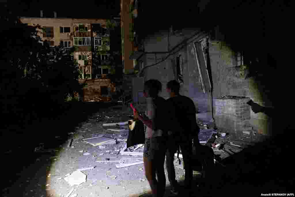 Localnicii își scot bunurile în afara clădirii deteriorate. Ministerul de Interne al Ucrainei a declarat că 29 de ofițeri de poliție și șapte salvatori au fost răniți într-o a doua lovitură cu rachete, după ce au răspuns la atacul inițial asupra orașului.