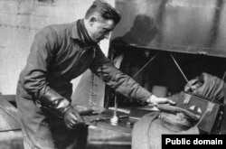 Lowell Smith a csomagjait rendezi a kétfedelű repülő csomagterében. A pilótáknak a súly- és helykorlátozás miatt nem volt mentőmellényük és ejtőernyőjük