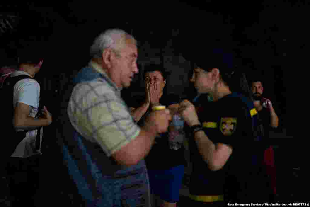 Localnici în apropierea clădiri administrative incendiate. Primarul din Odesa, Hennadi Truhanov, a descris atacul ca fiind &bdquo;una dintre cele mai rele nopți din istorie&rdquo;, adăugând că o persoană a fost rănită.