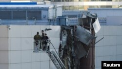 Istražitelji rade u blizini oštećenog krova nakon što je prijavljeni ukrajinski dron oboren u Moskvi, Rusija, 18. avgusta 2023.