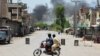 Pakistanezët shikojnë tymin që del pas një sulmi vetëvrasës, që dyshohet se u kry nga militantët në Banu më 15 korrik 2024. 