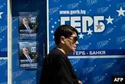 O femeie trece pe lângă afișe de campanie pentru partidul de centru-dreapta GERB din Bulgaria, la Sofia, pe 7 iunie 2024.