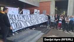 Okupljeni su ispred fakulteta razvili transparente na kojima piše "Akademska zajednica teba da se stidi, tog čoveka kraj sebe da vidi" i "Položićemo i ovaj ispit", Novi Sad, 28. mart 2024.
