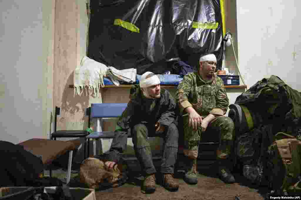 Ushtarët ukrainas që u plagosën në fushën e betejës, pasi kanë marrë trajtimin mjekësor të nevojshëm, presin të largohen nga spitali fushor.