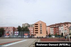 Fëmijët luajnë në një fushë basketbolli pranë një grafiti ku shkruan “Kur ushtria të kthehet në Kosovë”, në Mitrovicën e Veriut.