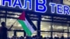 Lokalni čovjek maše palestinskom zastavom s porukom "Dagestan s vama", na aerodromu Mahačkala, Dagestan, Ruska Federacija, 29. 10. 2023.