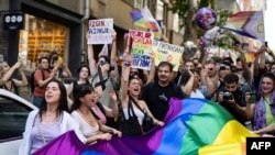 Членови и поддржувачи на ЛГБТК заедницата држат знамe во боите на виножито и извикуваат слогани за време на неовластениот Марш на гордоста во Истанбул, на 25 јуни 2023 година.