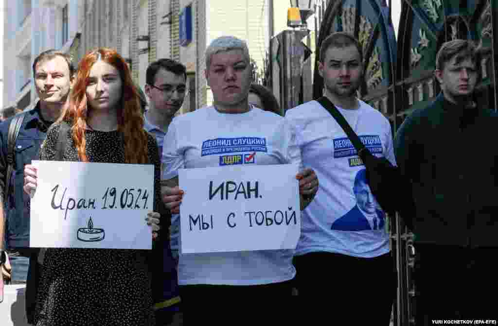 Люди держат плакаты с надписями &laquo;Иран &mdash;&nbsp;19.05.2024&raquo; (слева) и &laquo;Иран, мы с тобой&raquo; возле посольства в Москве