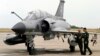 Piloții francezi stau lângă un avion de luptă Mirage. 