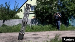Празен контейнер с касетъчни боеприпаси, забит в земята след военен удар в рамките на войната в покрайнините на Харков, Украйна, 10 юни 2022 г.