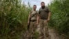 Soldații ucraineni Rostislav (stânga) și Oleksandr patrulează pe malul râului în Prîmorske.
