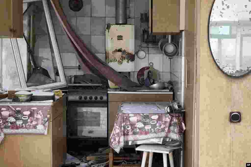 O fotografie făcută cu drona surprinzând rămășițele unei bucătării dintr-o clădire de apartamente a cărei fațadă a fost distrusă.