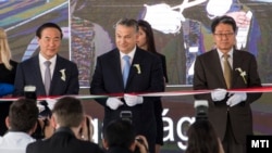 Orbán Viktor miniszterelnök átvágja a nemzeti színű szalagot a Samsung SDI gödi akkumulátorgyárának nyitóünnepségén, 2017. május 29-én