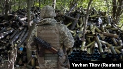 Një ushtar ukrainas qëndron pranë predhave të përdorura nga ushtria ukrainase gjatë luftës kundër pushtuesit, Rusisë, në rajonin e Donjeckut, 11 tetor 2023.