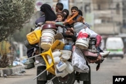 Palestinska porodica na triciklu beži iz Rafe na jugu Gaze usred najava ofanzive Izraela na taj grad, 11. maj 2024.
