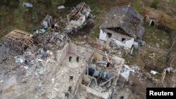 Спасувачките екипи ги отстрануваат остатоците на местото на зградите на локалното кафуле и продавница за храна, каде што најмалку 52 лица загинаа од руски ракетен напад, среде рускиот напад врз Украина, во селото Хроза, во регионот Харкив, Украина на 6 октомври, 2023 година.