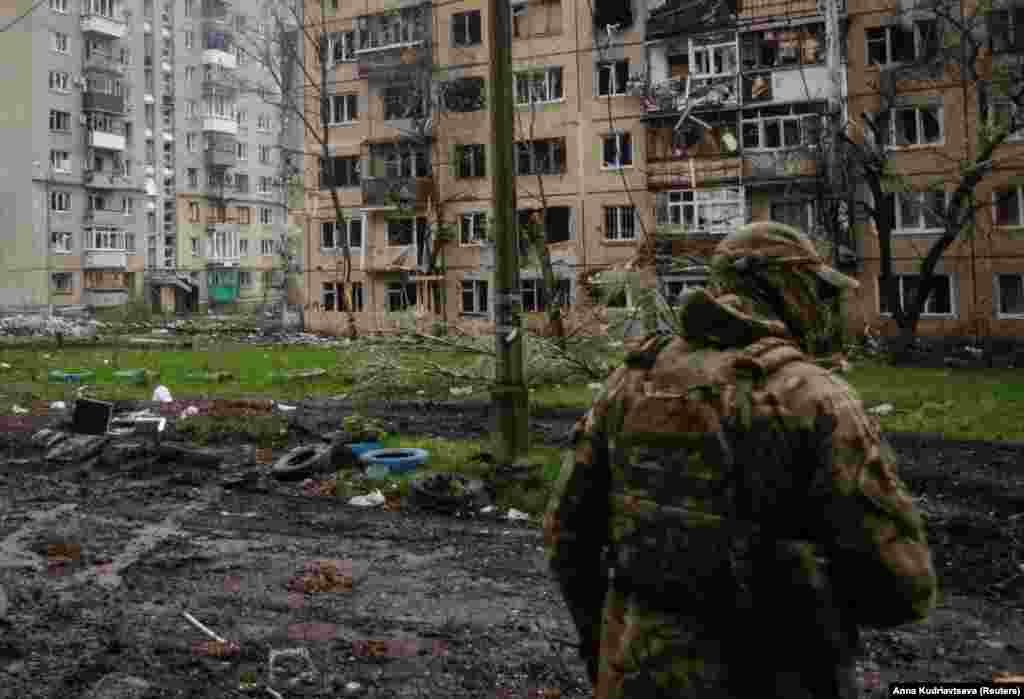 Un soldat ucrainean în patrulare printre blocurile avariate din Bahmut. Comentariile lui Sîrski au fost făcute după ce Ministerul rus al Apărării a declarat la 23 aprilie că forțele sale au capturat două districte din partea de vest a orașului. Afirmația nu a putut fi verificată din surse independente.