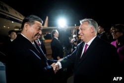Președintele chinez Xi Jinping (stânga) este întâmpinat de prim-ministrul ungar Viktor Orban pe aeroportul Liszt Ferenc din Budapesta. Ungaria, 8 mai 2024.