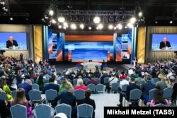 Ruski predsednik Vladimir Putin na velikim ekranima dok govori na svoj konferenciji za novinare.