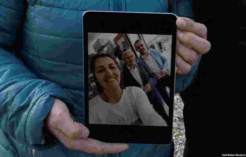 Bedia Zuberoglu, 46 vjeç, tregon një foto të kunatit të saj Samet Zuberoglu, 33 vjeç, i cili vdiq së bashku me gruan e tij gjatë tërmetit të vitit të kaluar, ndërsa qëndron në një zonë banimi të pastruar ku dikur ndodhej shtëpia e Sametit, në Hataj, Turqi. Shkurt 2024.