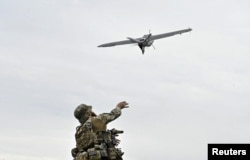 Un militar ucrainean lansează o dronă de recunoaștere pentru a survola pozițiile trupelor ruse, pe fondul atacului Rusiei asupra Ucrainei, în regiunea Zaporijie, Ucraina, mai 2024.