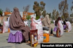 Afganistanke sjede nakon što su primile pomoć u hrani koju je podijelila dobrotvorna fondacija tokom muslimanskog svetog mjeseca ramazana u Kandaharu.