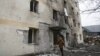 Një person kalon pranë një ndërtese banimi të dëmtuar nga një sulm rus me dronë. Odesa, 14 dhjetor 2023. 