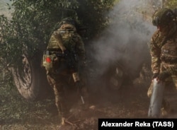 Руски војник со мало советско знаме на опремата пука со хаубица во областа Луганск во Украина на 4 октомври