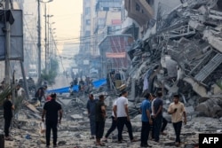 Locuitorii din Gaza au ieșit pe străzi după ce mai multe clădiri s-au prăbușit în urma atacului aerian israelian de duminică.