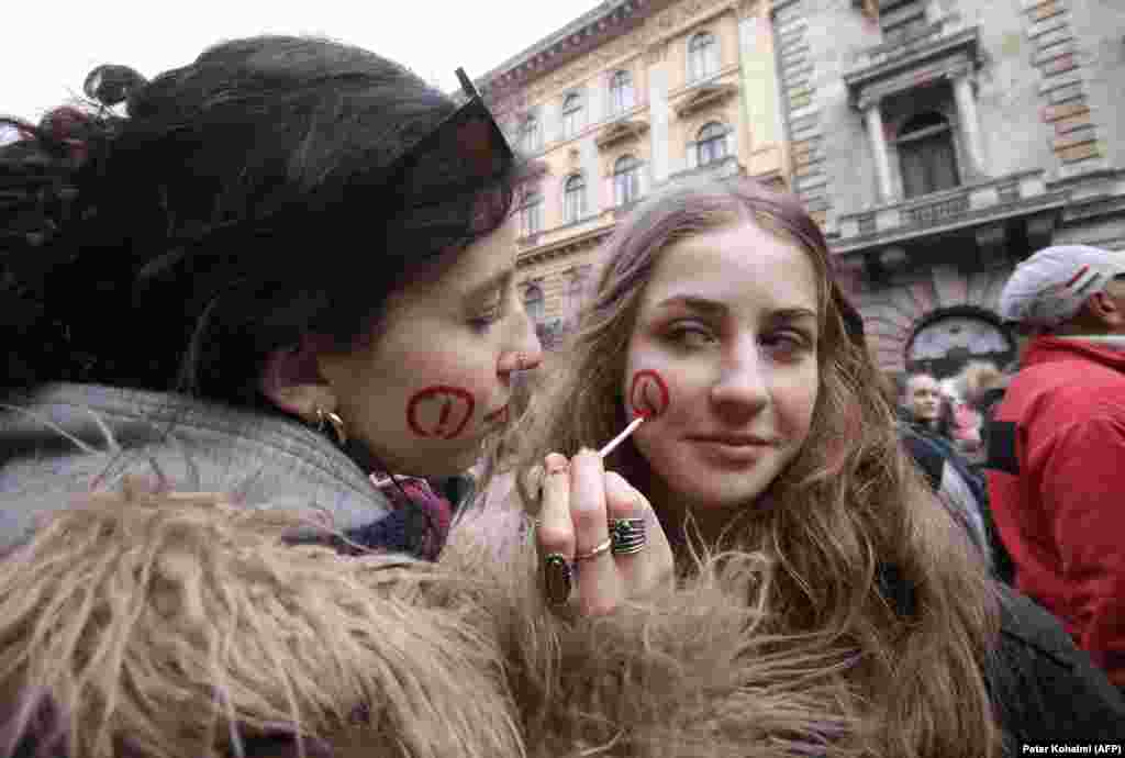 Vajzat tregohen kreative me pikturimin e fytyrave të tyre ndërsa marrin pjesë në demonstratë.