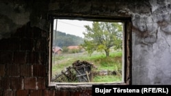 Lëndina ku u vranë civilët shqiptarë të fshatit Landovicë shihet nga dritarja e shtëpisë së dëmtuar gjatë sulmit të forcave serbe në luftën e vitit 1999.