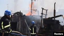 Pompierii ucraineni sting un incendiu provocat de atacul cu rachete rusesc asupra portului Odesa, 23 iulie 2022.