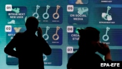 Visitors stand in front of an electronic board displaying cryptocurrency promotions at the Thailand Crypto Expo in Bangkok in May.
