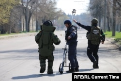Geniștii verifică dacă există mine de-a lungul unei străzi din Harkov.
