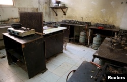 O pisică este fotografiată în bucătăria unui cămin de muncitori străini din zona industrială Sanaya din Doha, 3 mai 2015. Muncitorii și grupurile de apărare a drepturilor omului au acuzat în repetate rânduri condițiile inadecvate în care trăiesc muncitorii străini din Qatar.