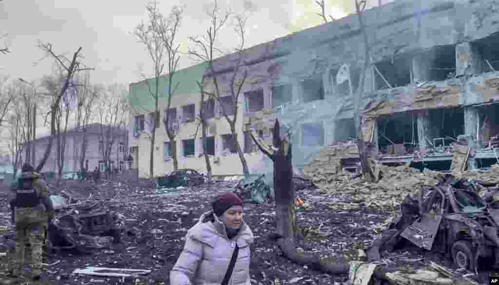 Një grua duke ecur mes rrënojave, pas sulmit rus ndaj spitalit të fëmijëve në Mariupol, më 9 mars.