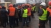 Migranții au trimis la RFE/RL imagini care arată un grup de bărbați - presupuși lucrători tadjici din Mariupol - care își cer salariile de la angajatori. (captură video)