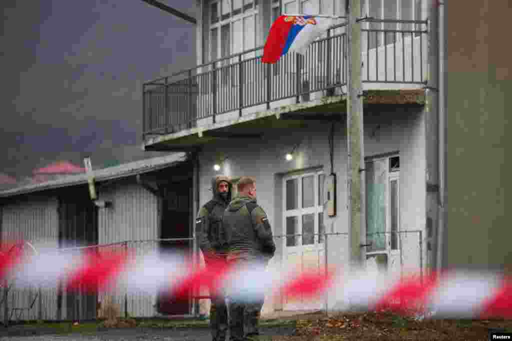 Paqeruajtësit e NATO-s nga Gjermania duke ecur para një bllokade rrugore të ngritur nga serbët e Kosovës në Rudarë, më 12 dhjetor.