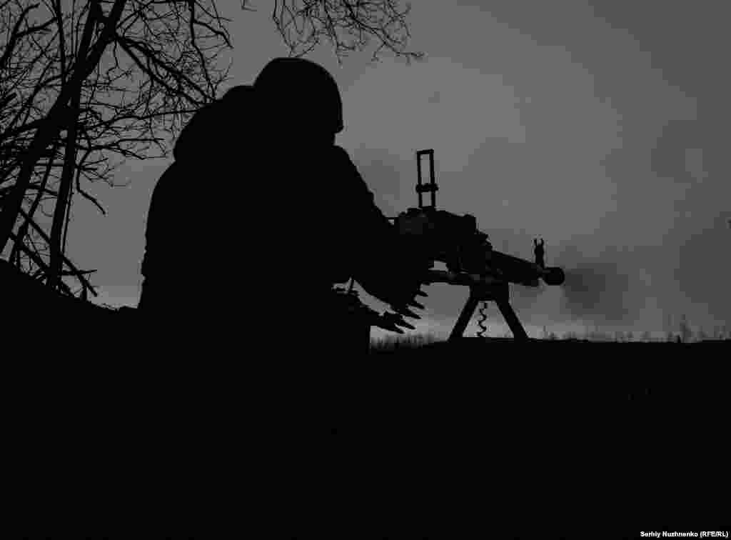 Un militar ucrainean trage salve de mitralieră contra pozițiilor rusești dinaspropiere de Soledar pe 14 ianuarie.&nbsp;Deși Soledar are o valoare militară infimă, cucerirea lui ar fi cea mai semnificativă victorie pe teren a Moscovei în mai multe luni de zile.