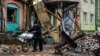 Un localnic trece cu bicicleta pe lângă capcane anti-tanc și ruine, pe o stradă din Bahmut, Donețk, 6 ianuarie.