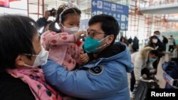 Njerëzit përqafohen në Aeroportin Ndërkombëtar të Pekinit, pasi Kina hoqi karantinimin për udhëtarët që vijnë në këtë shtet. 8 janar 2023. REUTERS/Thomas Peter